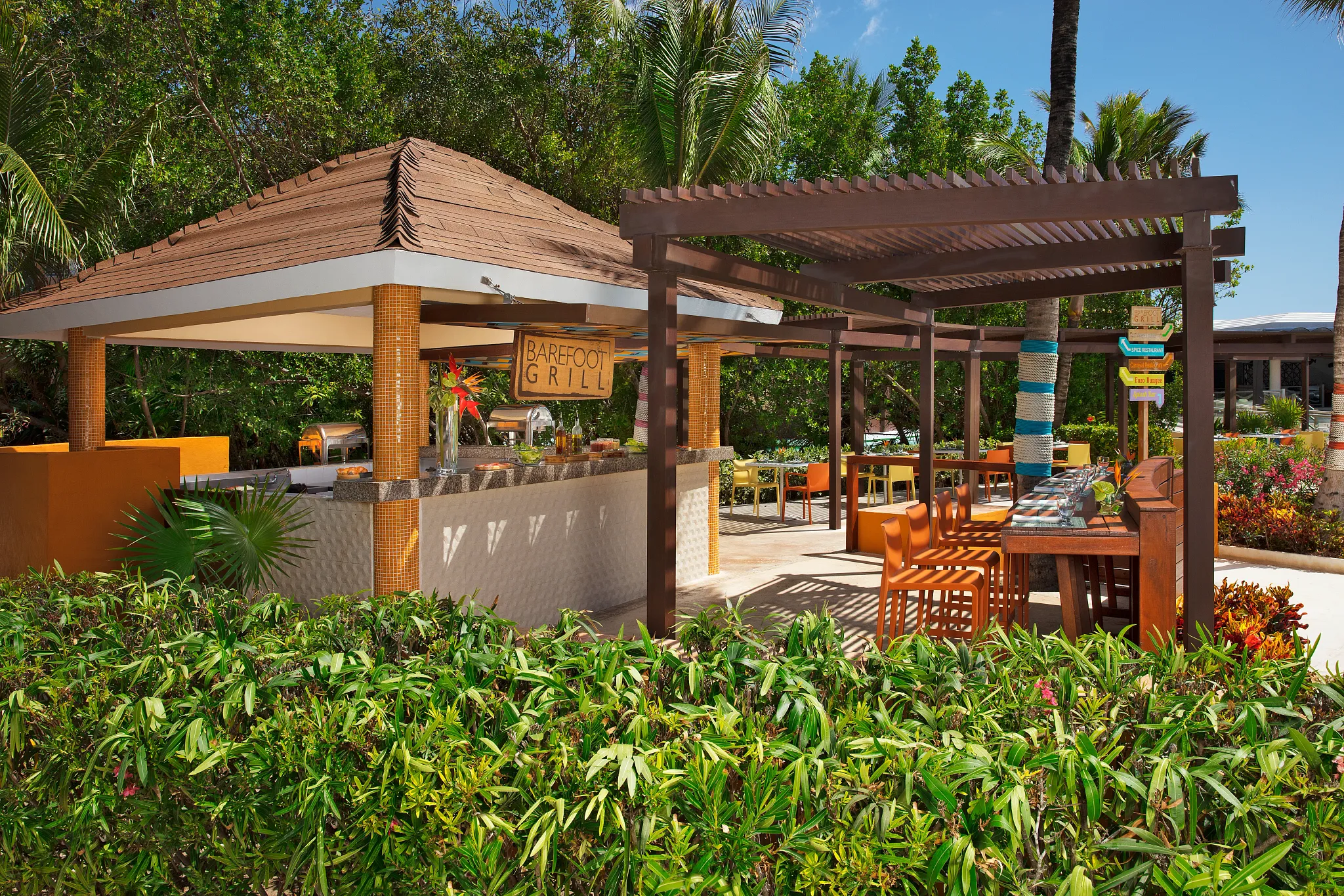 Barefoot Grill at Dreams Jade Resort & Spa featuring a casual open-air poolside dining area surrounded by tropical gardens.