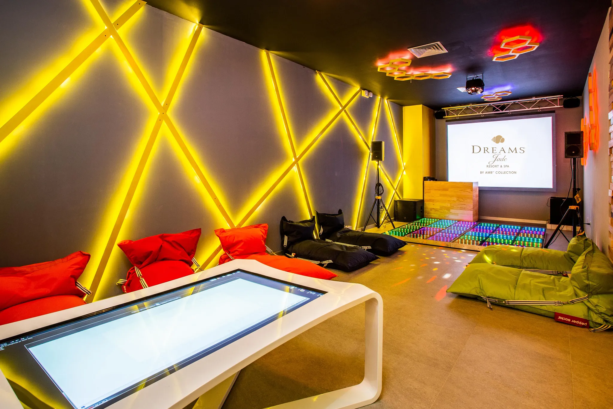 Core Zone Teen Lounge with interactive games and neon lighting at Dreams Jade Resort & Spa.