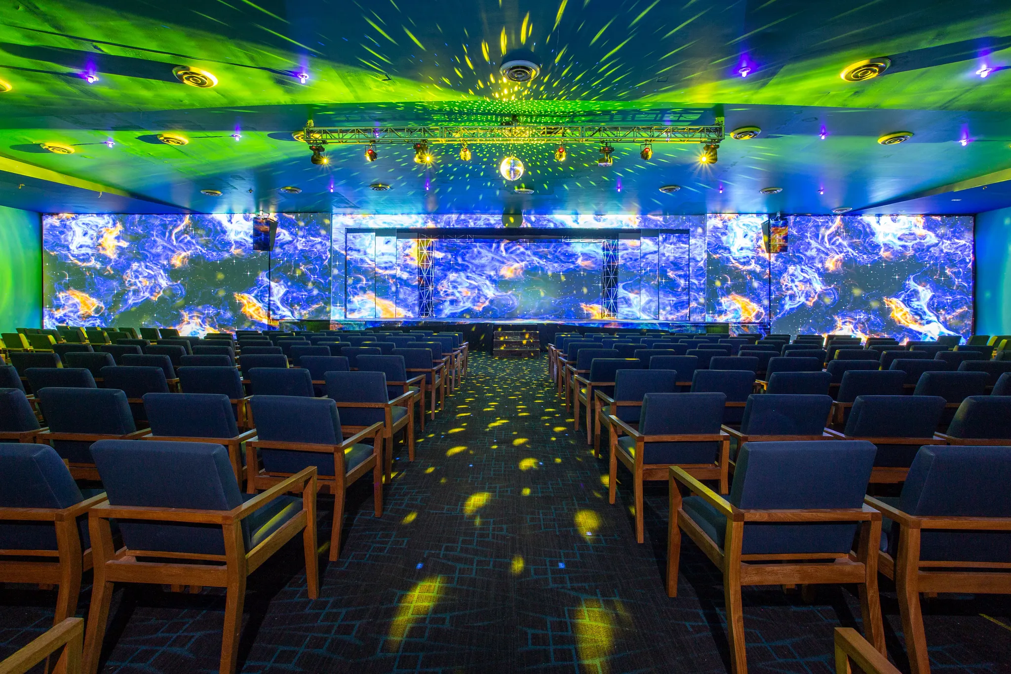 Indoor theater stage with lighting effects at Dreams Jade Resort & Spa.