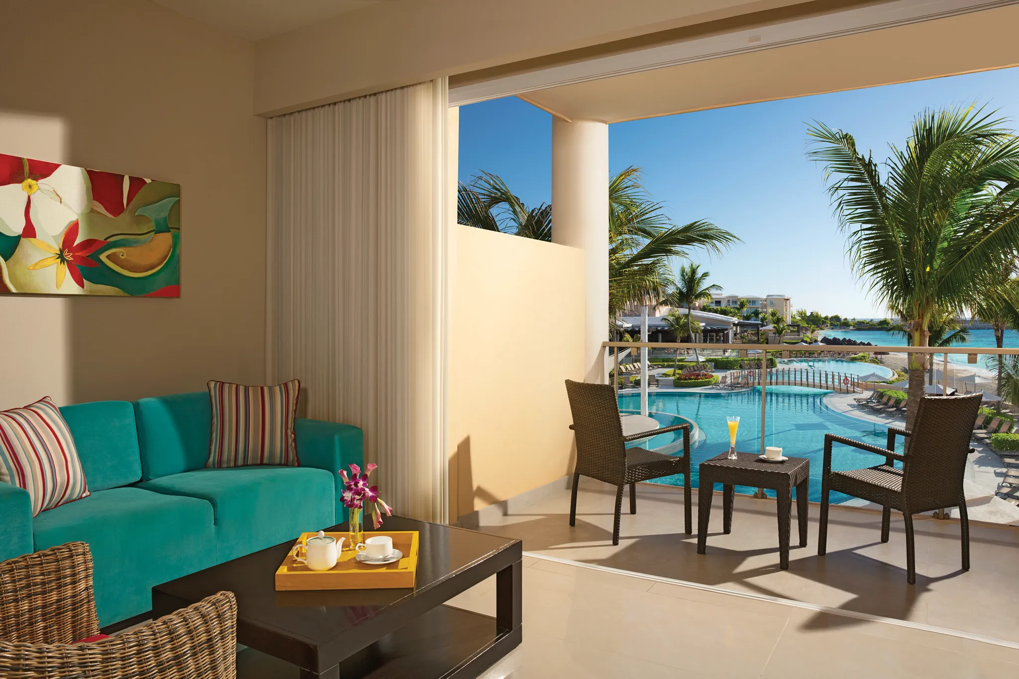 Junior Suite Ocean Front View balcony with seating area overlooking pool and ocean at Dreams Jade Resort & Spa.