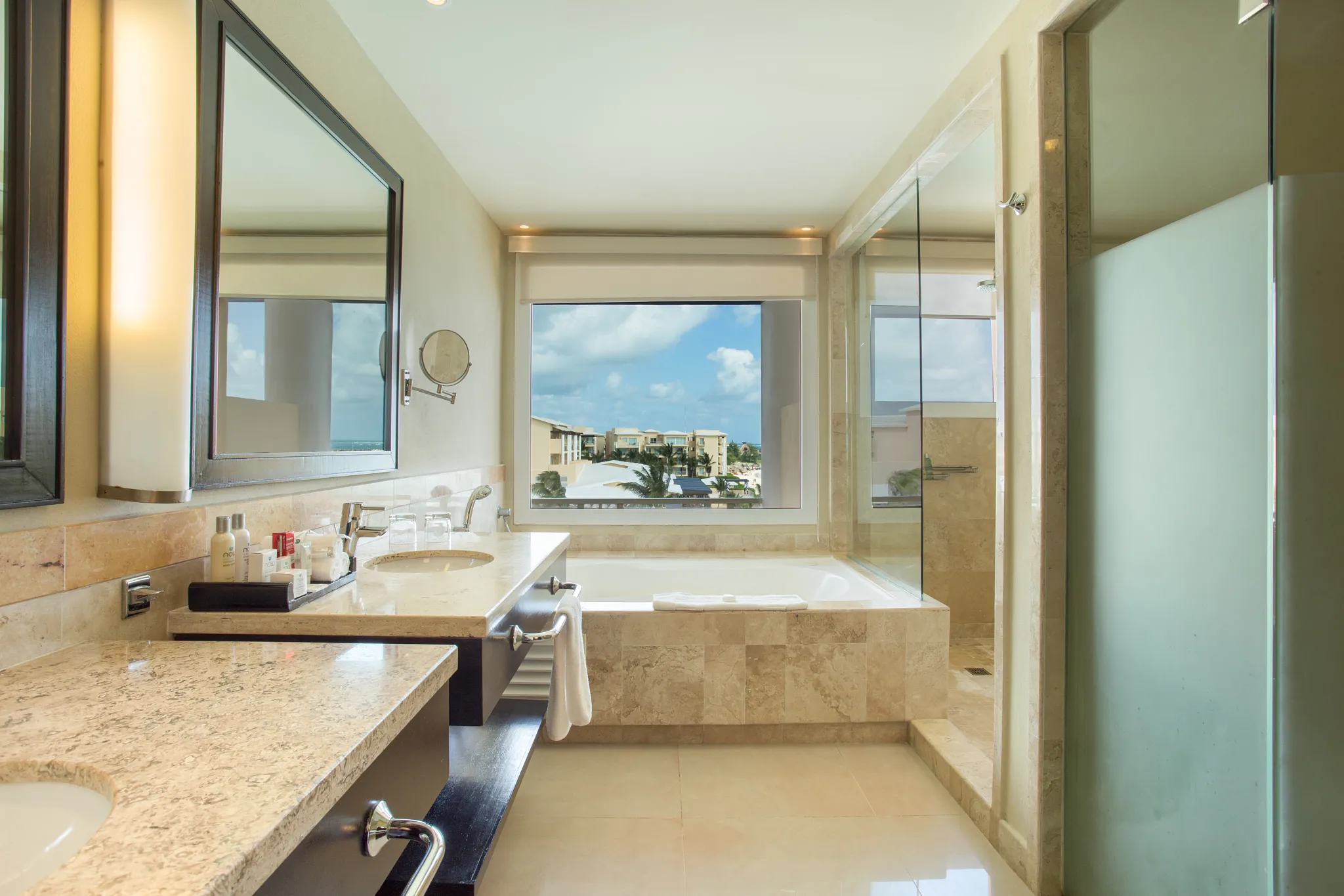 Junior Suite Ocean View bathroom with soaking tub, dual vanities, and glass-enclosed shower at Dreams Jade Resort & Spa.