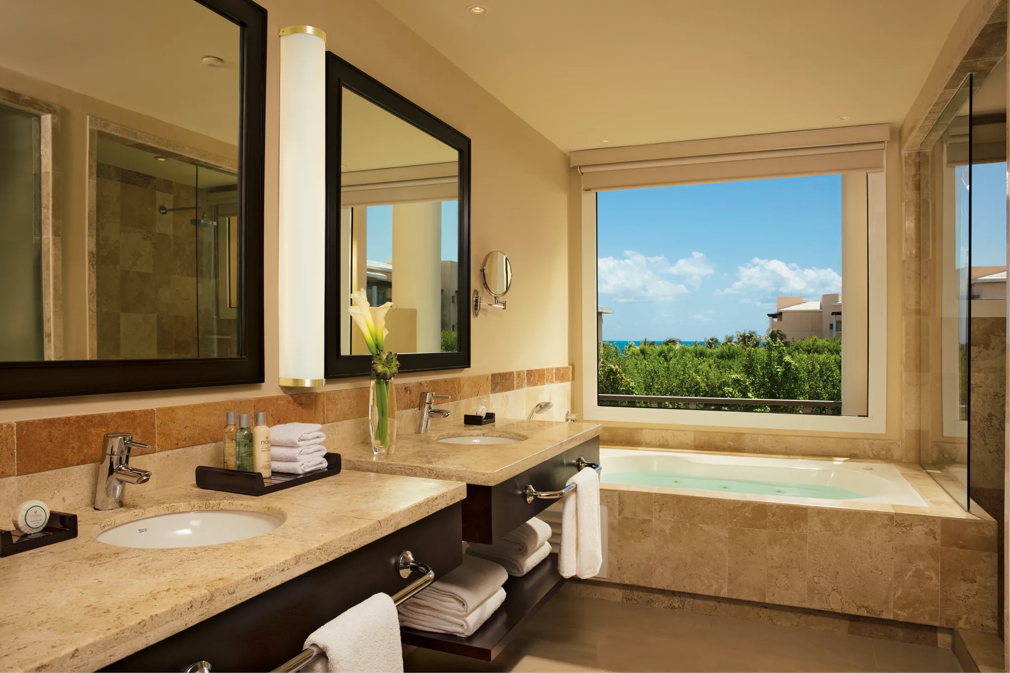 Junior Suite Tropical View bathroom with double sinks and soaking tub at Dreams Jade Resort & Spa.