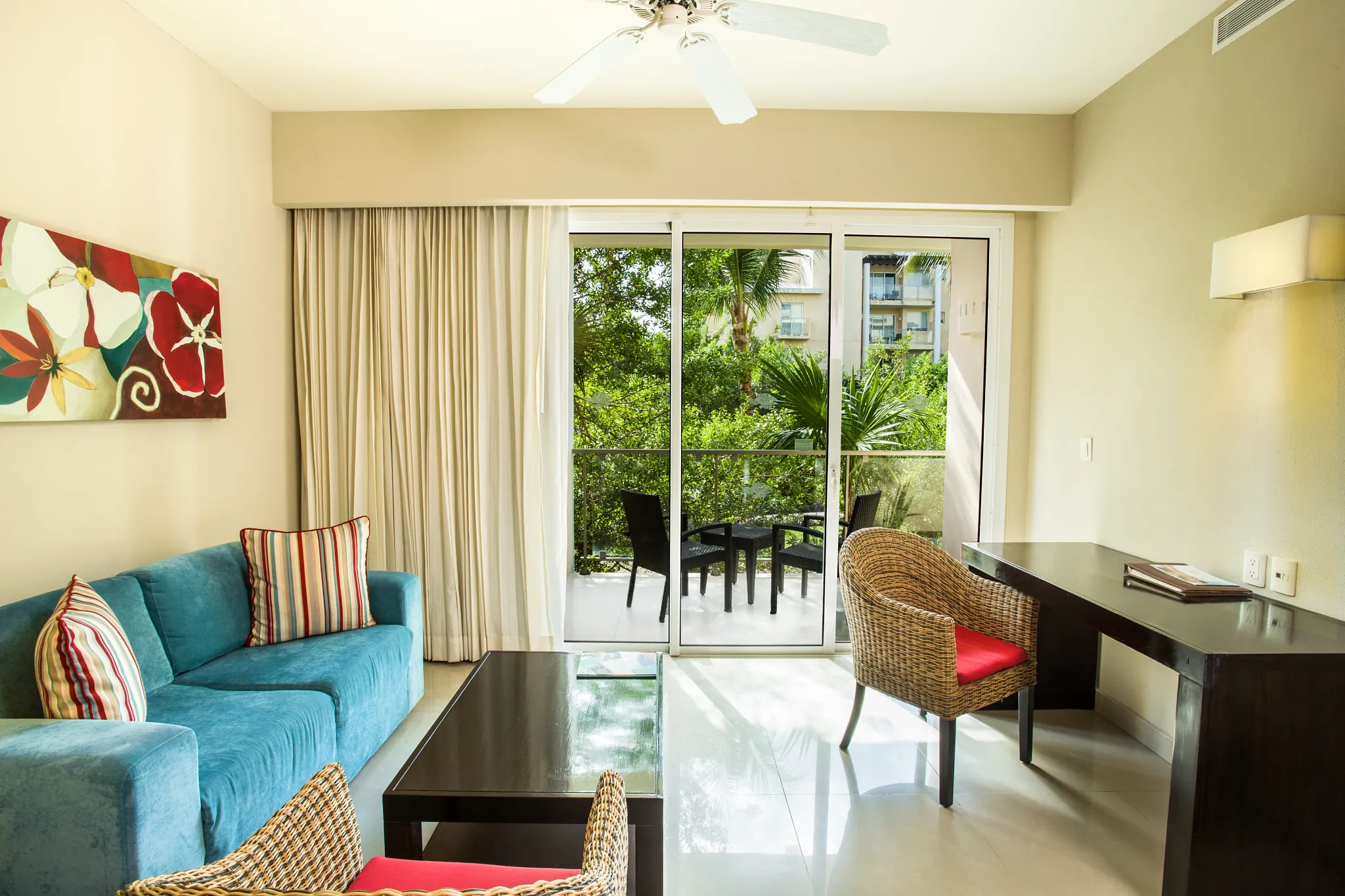 Junior Suite Tropical View living area with sofa and private furnished balcony at Dreams Jade Resort & Spa.