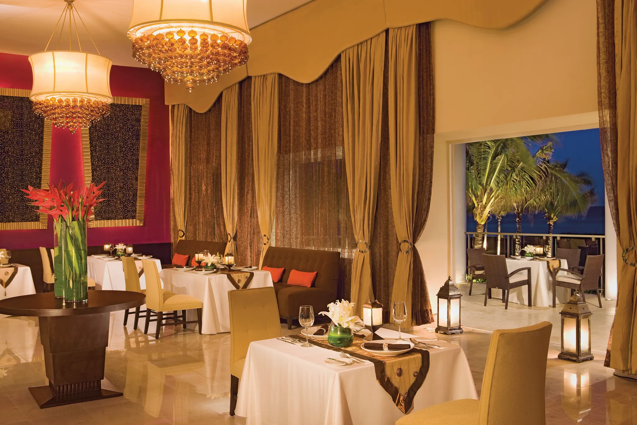 Mercure French restaurant at Dreams Jade Resort & Spa featuring elegant indoor dining, candlelit tables, and garden terrace views.
