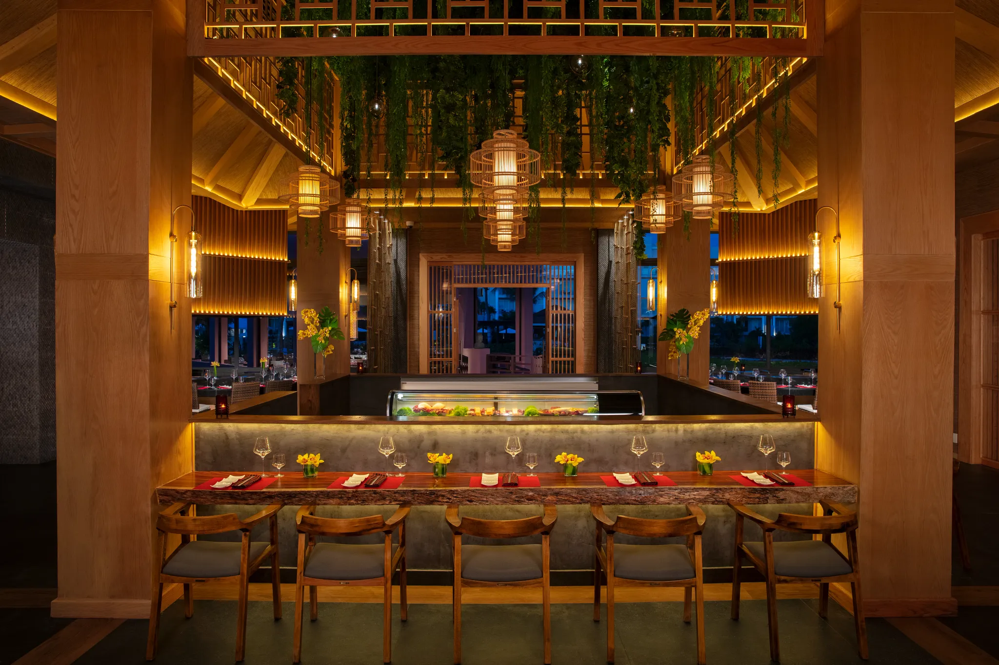 Spice Asian restaurant at Dreams Jade Resort & Spa featuring sushi bar seating, teppanyaki tables, and warm Zen-inspired décor.