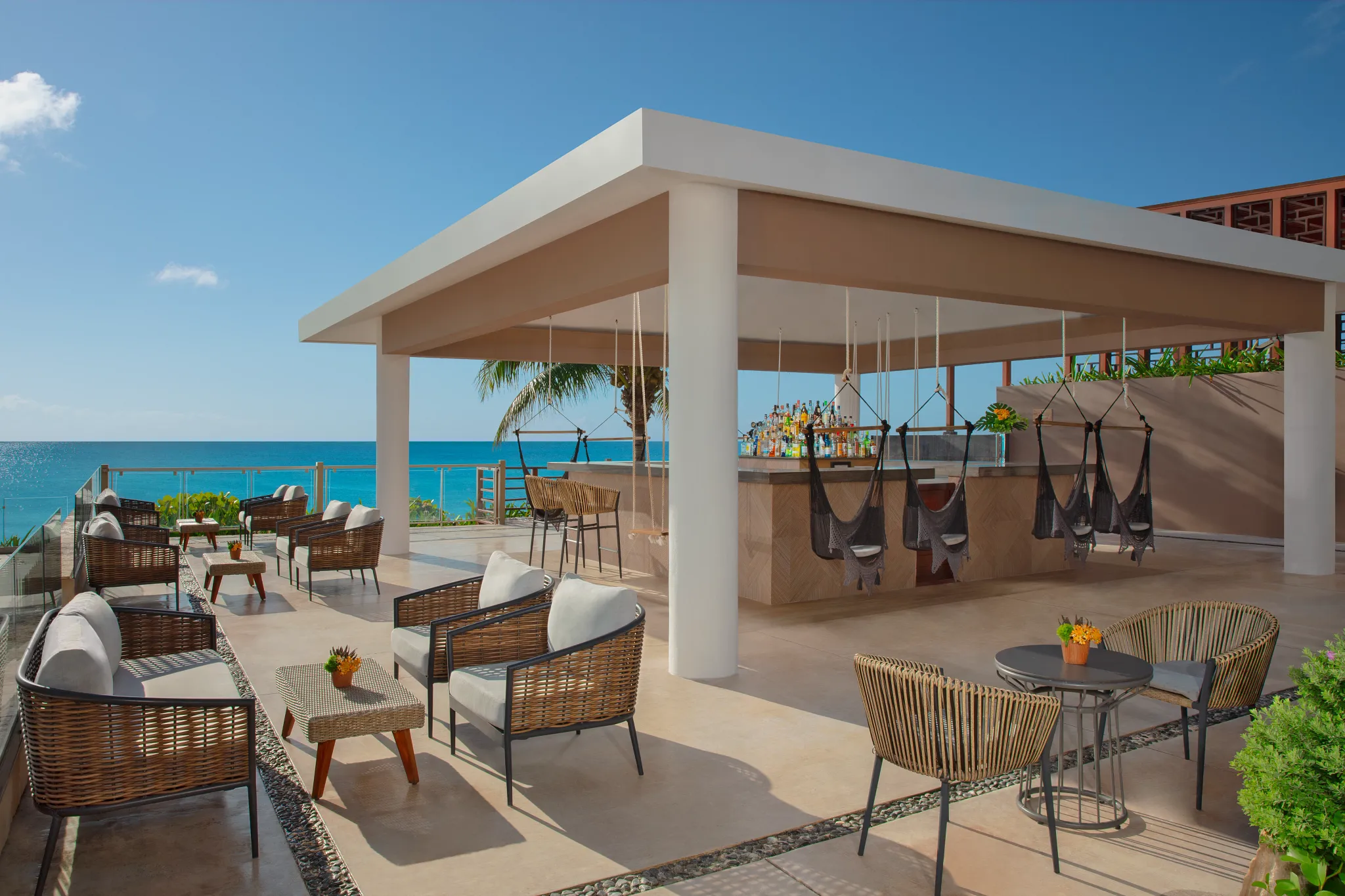 The Mix beach bar at Dreams Jade Resort & Spa featuring oceanfront seating, hanging swing chairs, and tropical cocktails.