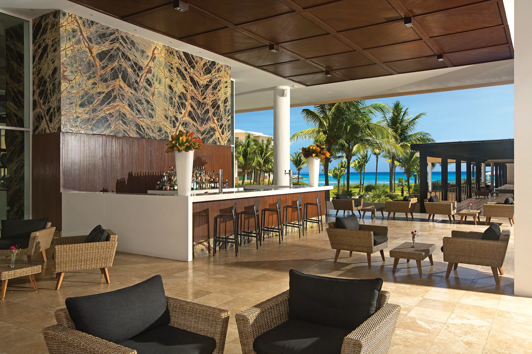 Time Out outdoor bar at Dreams Jade Resort & Spa featuring ocean views, open-air seating, and modern bar area.